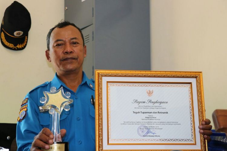 Teguh Tuparman (56) menunjukkan penghargaan Keluarga Hebat dari Kementerian Pendidikan dan Kebudayaan RI.