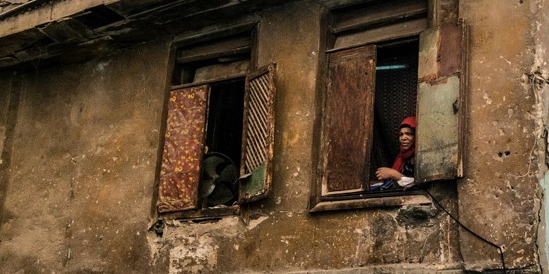 Seorang wanita Mesir melihat keluar jendela dekat masjid al-Azhar di Kairo pada 2 April 2020, karena sebagian besar penduduk ibukota tetap di dalam ruangan selama krisis pandemi coronavirus yang baru. 