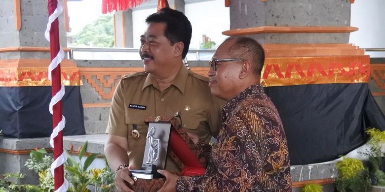 Wakil Bupati Gianyar Anak Agung Gede Mayun (kiri) sedang menerima penghargaan dari Dirut BPJS Ketenagakerjaan.