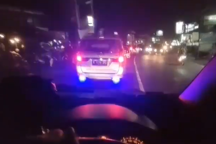 Sebuah mobil menggunakan lampu sorot sebagai lampu rem yang mengganggu pengguna jalan lain.