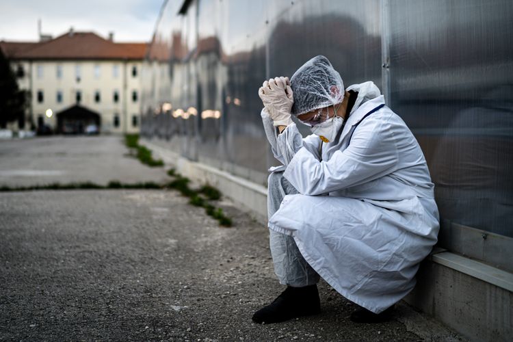 A medical worker in front of his hospital