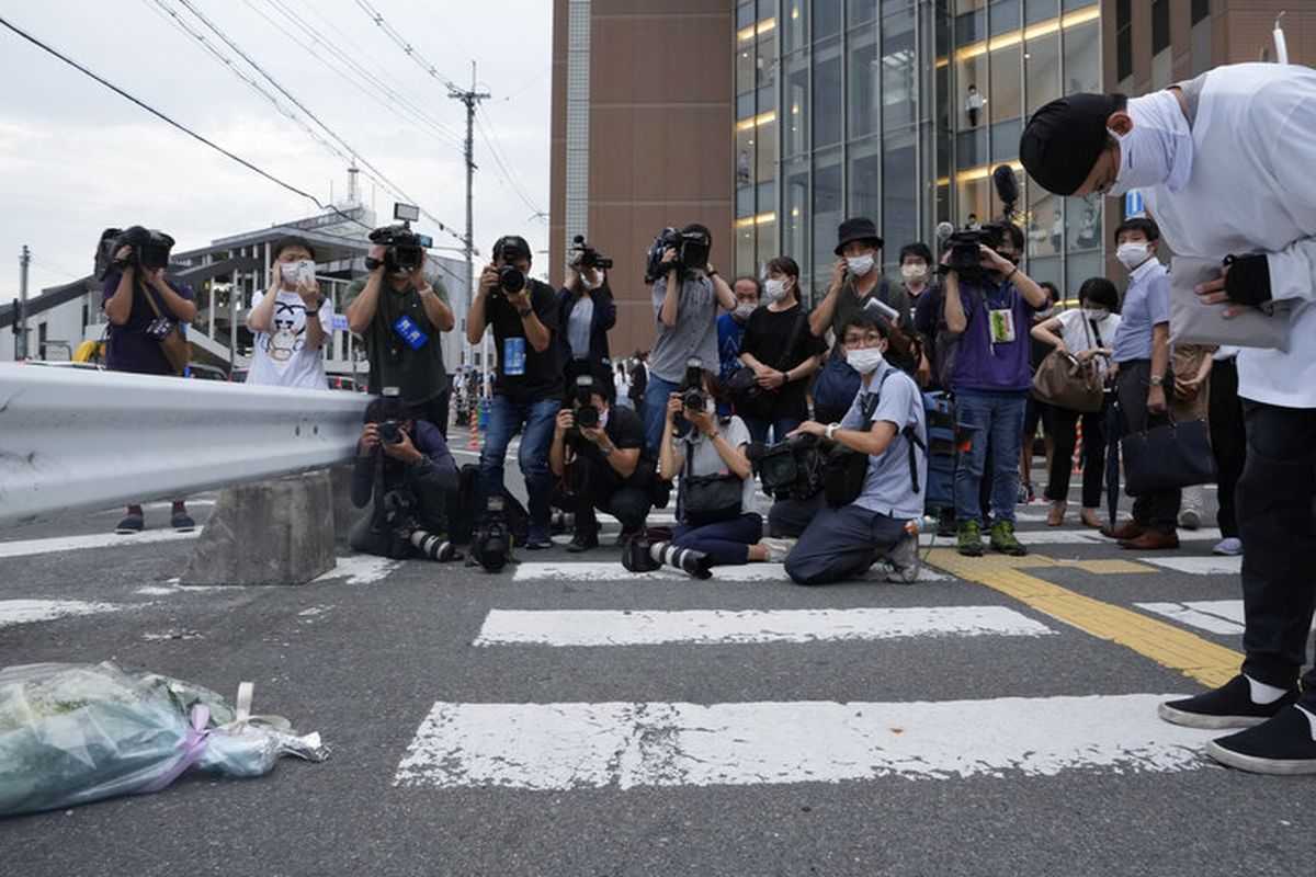 A mourner prays and lays flowers at the site where former prime minister of Japan Shinzo Abe was shot in the chest during a campaign speech on a street outside a train station in the city of Nara, just east of Osaka, at about 11:30 a.m. local time Friday, July 8, 2022. 