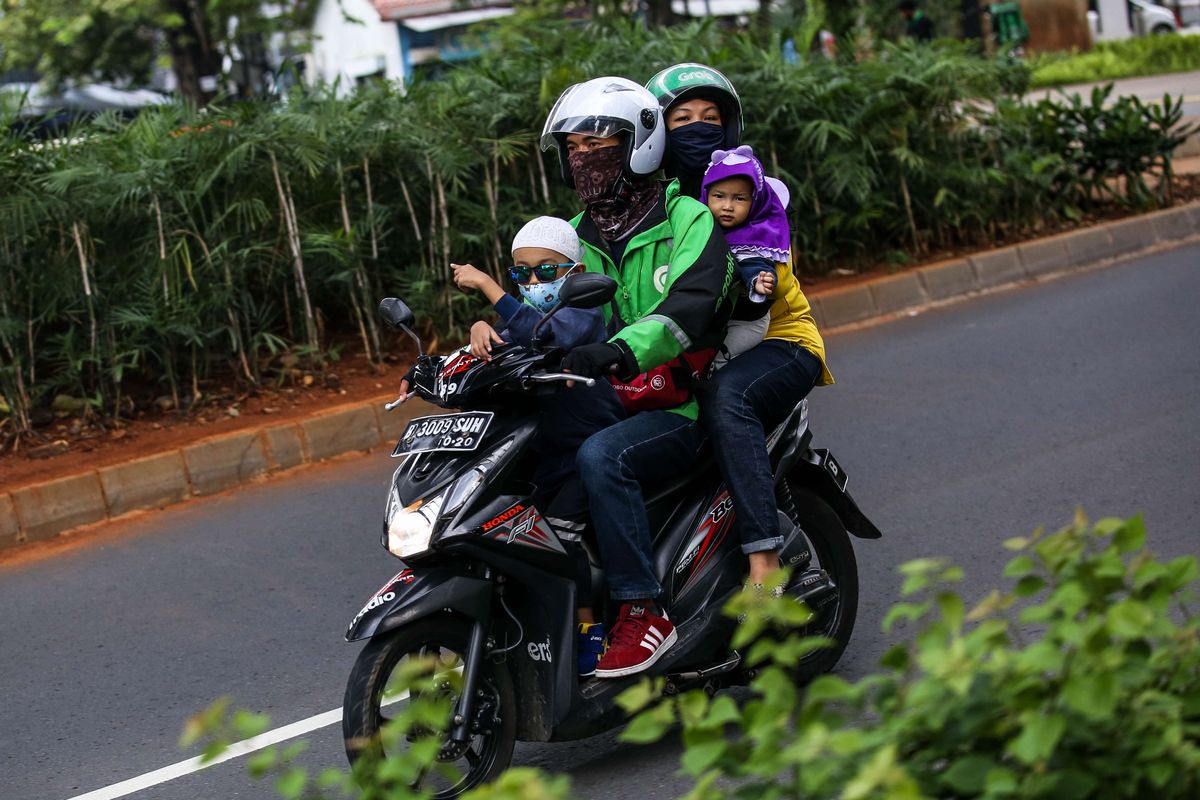 Pengemudi ojek online dengan penumpangnya melintas di Jl. Prof. DR. Satrio, Jakarta Selatan, Senin (8/6/2020). Pemerintah Provinsi DKI Jakarta mengizinkan pengemudi ojek online beroperasi untuk mengangkut penumpang selama PSBB transisi dengan menerapkan protokol kesehatan.