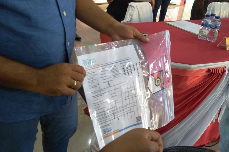 Barang bukti surat hasil tes PCR swab test yang dipalsukan oleh tersangka AHM (51) kepada calon penumpang berinisial DNS yang akan terbang ke Jakarta. Surat PCR yang dijual pelaku seharga Rp 750 ribu tanpa pengambilan sampel dan uji lab, selesai dalam waktu satu jam.