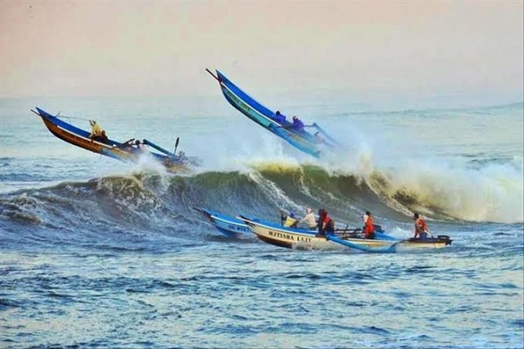 Perahu nelayan menerjang gelombang tinggi di perairan Teluk Penyu, Cilacap, Jawa Tengah