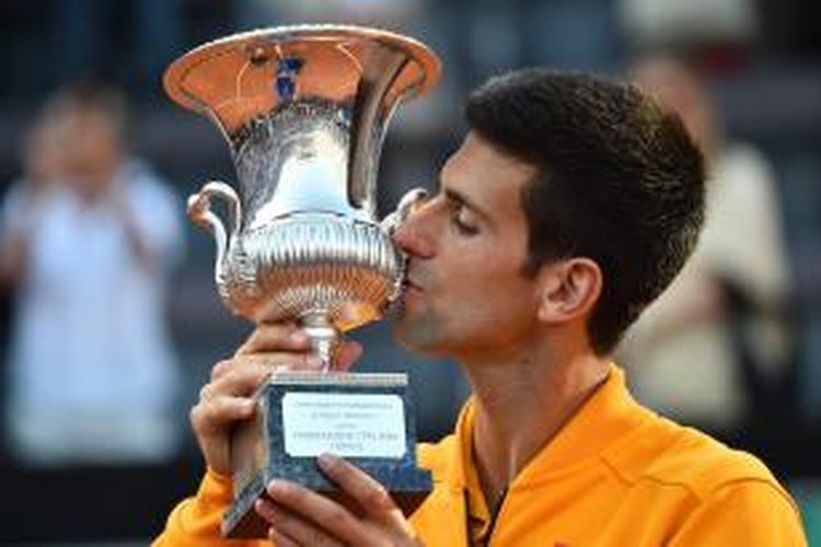 Petenis Serbia, Novak Djokovic, mencium trofi juara Roma Masters yang didapat setelah mengalahkan Roger Federer dari Swiss, 6-4, 6-3, Minggu (17/5/2015).