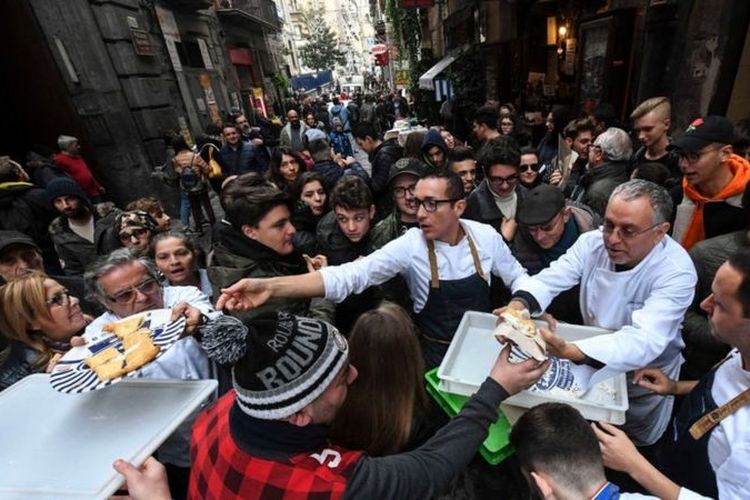 Sekelompok koki membagikan pizza kepada para turis di Napoli, Desember 2017, untuk merayakan status warisan dunia yang diberikan Unesco untuk pizza neapolitan.
