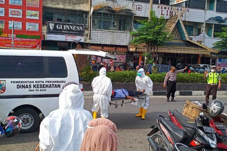 Petugas Puskesmas dengan mengenakan APD mengevakuasi seorang kakek yang pingsan di Pasar Cik Puan, Pekanbaru, Kamis (21/5/2020). Dok. Istimewa
