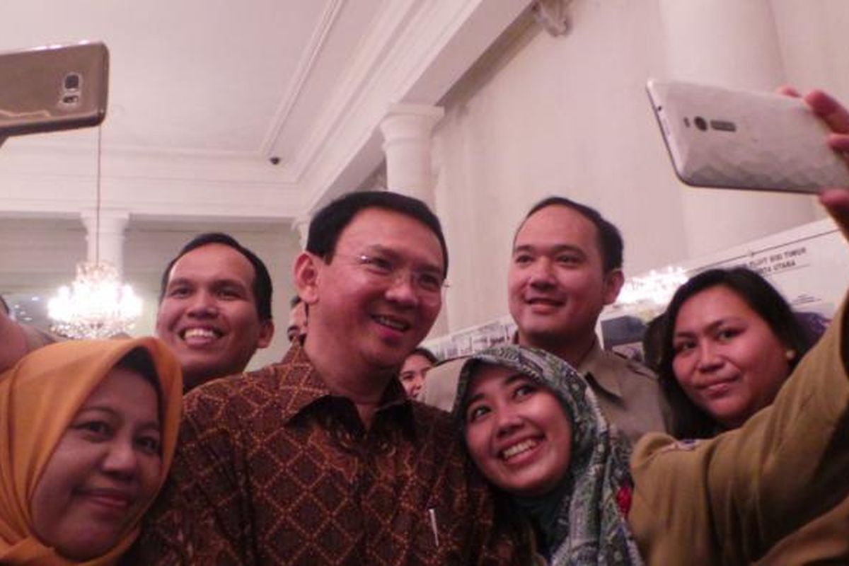 Gubernur DKI Jakarta Basuki Tjahaja Purnama berselfie dengan pegawai negeri sipil (PNS) DKI Jakarta, di Balai Kota DKI Jakarta, Senin (11/7/2016).
