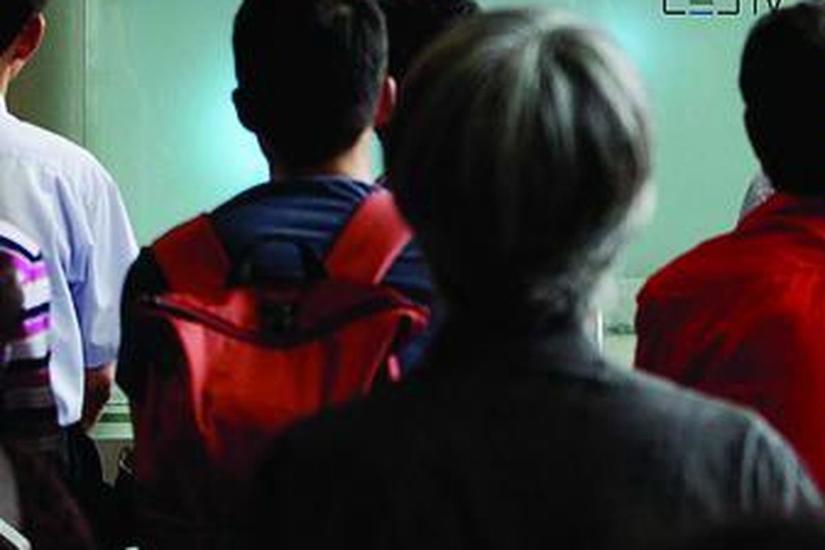 Warga Korea Selatan  menyaksikan siaran berita di televisi tentang pemimpin Korea Utara, Kim Jong Un, di stasiun kereta api di Seoul, Rabu (18/7). Kim kemarin mendapat gelar marsekal, gelar militer tertinggi Korut, yang menegaskan statusnya sebagai pemimpin tertinggi militer di negeri itu, dua hari setelah digesernya Panglima Angkatan Bersenjata  Ri Yong Ho. 