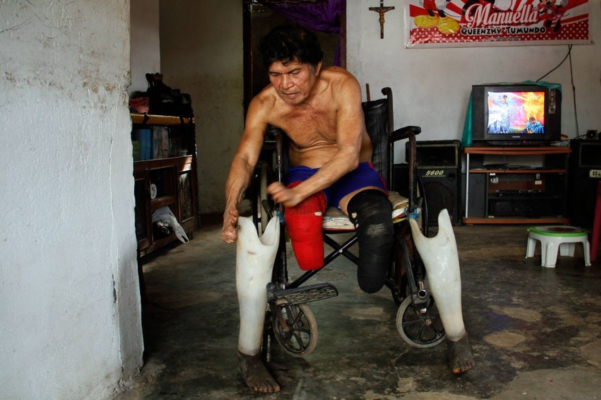Zeth, orang yang pernah mengalami kusta, membetulkan kaki palsunya di rumahnya di Kelurahan Pandu, Kecamatan Bunaken, Manado.