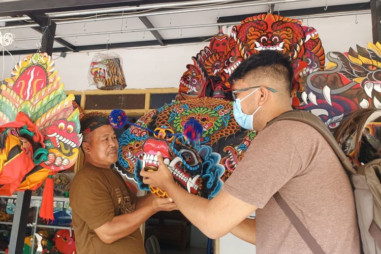 Pelaku UMKM mainan replika topeng mainan kesenian tradisional di Kelurahan Penarukan, Kecamatan Kepanjen, Kabupaten Malang, Johan Untung menunjukkan topeng kesenian tradisional hasil produksinya.