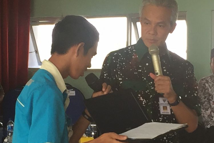 Gubernur Jawa Tengah Ganjar Pranowo berikan hadiah kepada Eden, siswa yang bisa menjawab pertanyaannya dalam kunjungan ke SMKN 1 Ampelgading, Kabupaten Pemalang, Jawa Tengah, Rabu (27/9/2017).