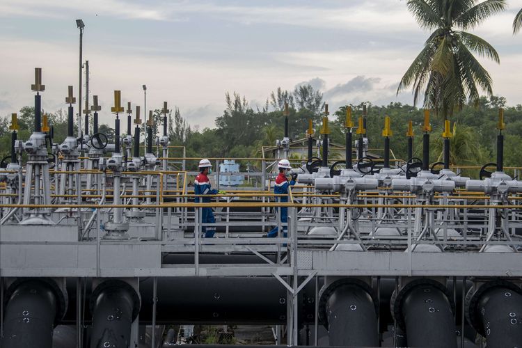 Pekerja PT Pertamina Hulu Rokan mengecek saluran pipa minyak yang menuju tangki pengumpul produksi minyak (Tank Farm) di Blok Rokan, Dumai, Riau.