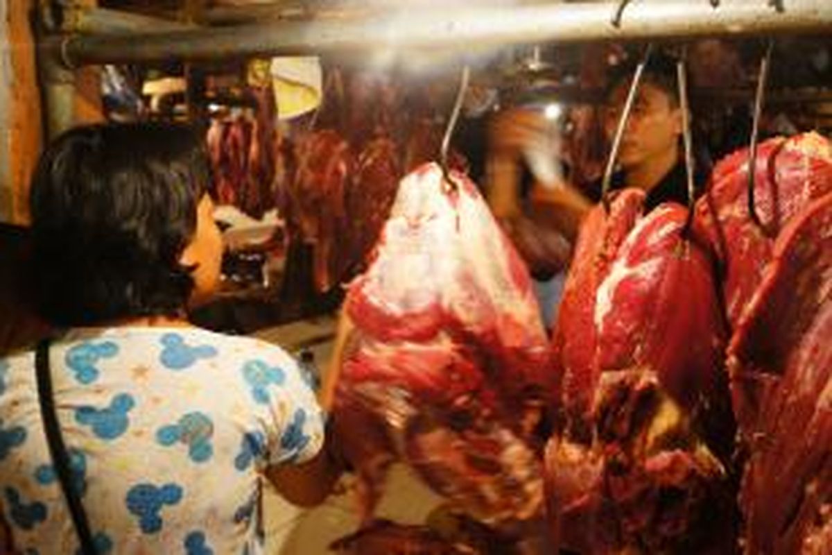 Pedagang daging sapi di Pasar Kramatjati melayani pelanggan, Jakarta, Jumat (27/6/2014). Harga daging sapi lokal di pasar tradisional masih di kisaran Rp 98.000 per kilogram.