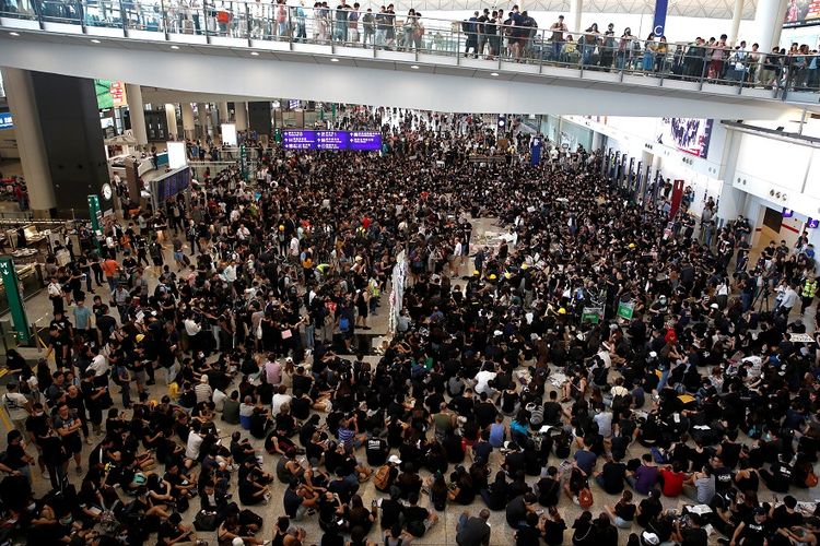 Massa demontran duduk dan berkumpul di aula kedatangan bandara internasional Hong Kong, pada Jumat (26/7/2019).