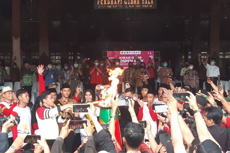 Wali Kota Solo Gibran Rakabuming Raka membawa api dalam kirab Pekan Olahraga dan Seni antar Pondok Pesantren Tingkat Nasional (Pospenas) IX Tahun 2022 di Balai Kota Solo, Selasa (22/11/2022).