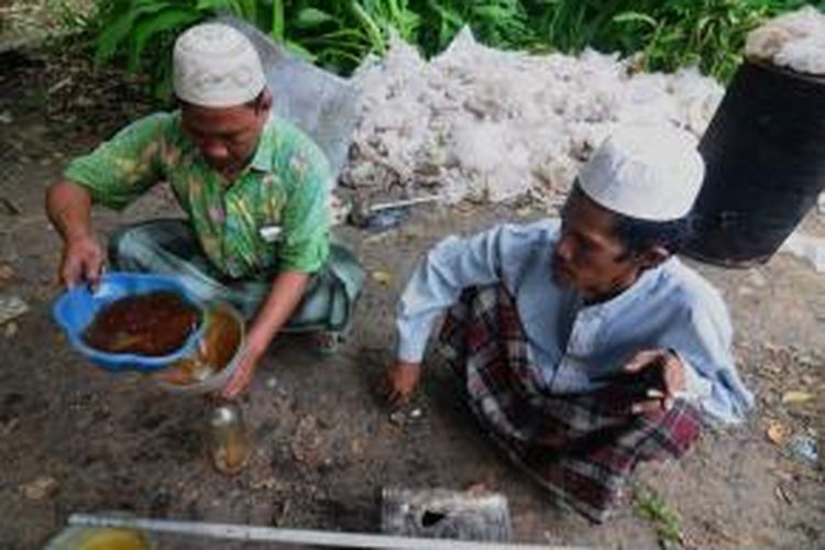 Mashuri menyaring hasil penyulingan sampah plastik untuk dijadikan bahan bakar motornya. 