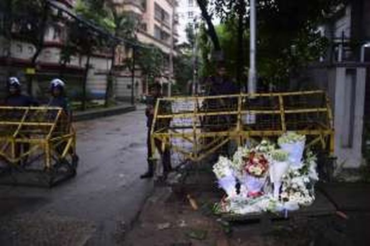 Polisi Banglades menjaga di depan lokasi pemeriksaan yang dipenuhi oleh bunga untuk para korban serangan teroris di Dhaka, Banglades, Minggu 3 Juli 2016. Sepekan terakhir sejumlah serangan bom terjadi di beberapa negara antara lain Turki, Bangladesh, Irak, Arab Saudi, dan terbaru terjadi di Solo, Indonesia.
