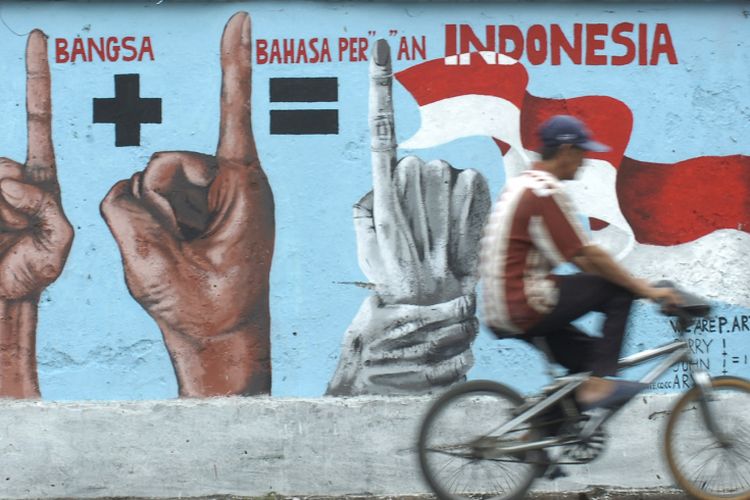 Pengendara sepeda melintasi mural yang mengobarkan semangat persatuan dan kesatuan, di Jalan Dinoyo Surabaya, Jawa Timur, Senin (27/10). Mengirimkan ucapan Hari Sumpah Pemuda 28 Oktober 2022 menjadi salah satu cara merayakannya.
