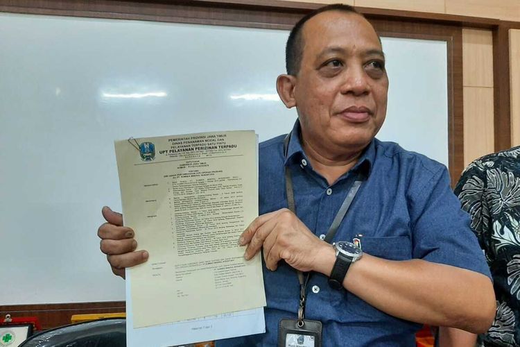 Kepala Dinas Penanaman Modal dan Pelayanan Terpadu Satu Pintu Priovinsi Jatim Aris Mukiyono menunjukkan izin pertambangan PT SMN yang belum diambil.