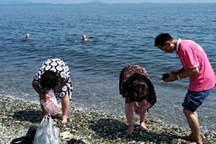 Dalam potongan gambar video, terlihat turis China memunguti kerikil di Pantai Ussuri, Rusia. Tingkah mereka membuat Konsulat Jenderal China di Vladivostok mengeluarkan peringatan.