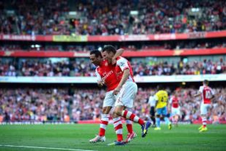 Bek Arsenal, Laurent Koscielny, merayakan golnya bersama rekannya, Santi Cazorla, seusai membobol gawang Crystal Palace, Sabtu (16/8/2014). 