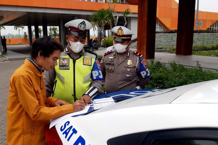Pengendara motor yang masuk ke jalan tol Jombang - Mojokerto, diminta petugas menandatangani pernyataan setelah dihentikan petugas PJR Polda Jawa Timur, Senin (14/2/2022).