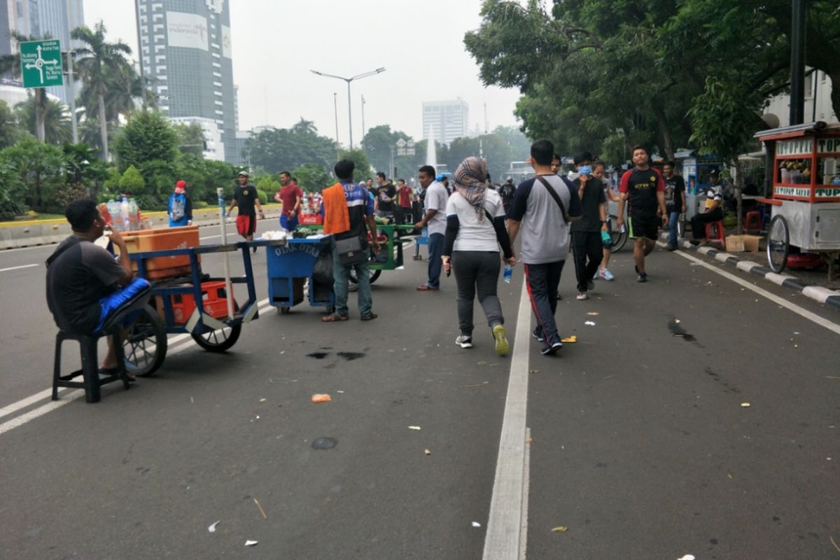 Para pedagang kaki lima (PKL) membuka lapaknya di badan jalan Sudirman-Thamrin saat car free day (CFD) digelar, Minggu (9/12/2018).