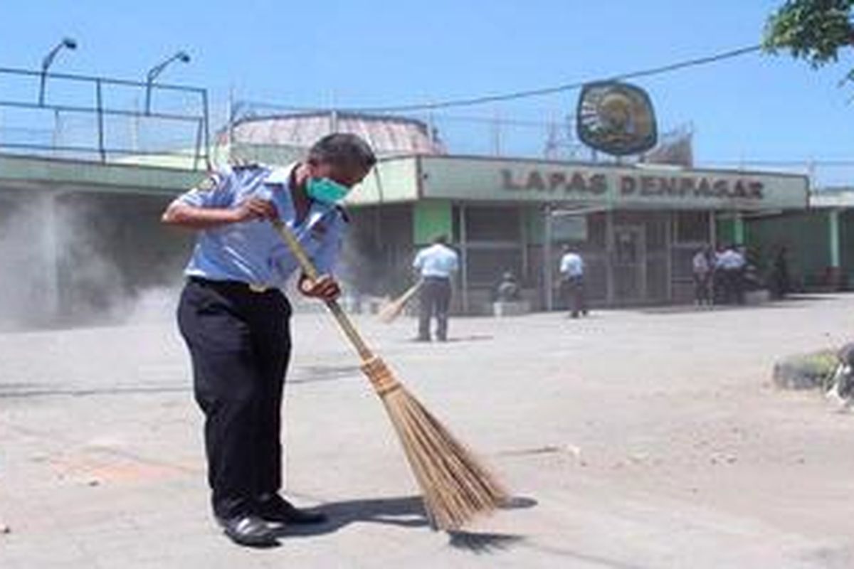 Seorang petugas Lembaga Pemasyarakatan Kelas IIA Kerobokan, Badung, Bali, sedang menyapu halaman LP yang kotor akibat kerusuhan, Jumat (24/2/2012). Pada Jumat kemarin, situasi LP berangsur normal dan petugas mulai membenahi gedung LP yang rusak. 