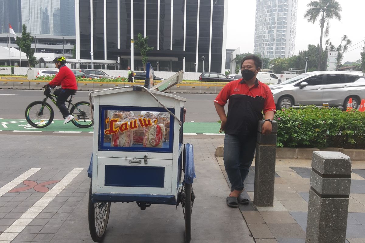 Komeng, salah seorang pedagang roti keliling saat mangkal di sekitar trotoar Jalan Sudirman, Jakarta, Sabtu (29/5/2021). Komeng adalah salah satu pedagang dengan sepeda yang mengaku terbantu dengan adanya jalur sepeda terproteksi.