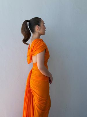 Laufey curi perhatian di Golden Globes 2026. Tampil bold dengan gaun Balenciaga oranye. Cek detailnya.