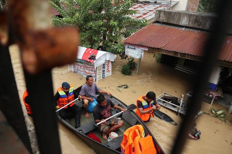 Sejumlah warga dievakuasi oleh personil Brimob Polda Sumut bersama warga lainnya di Kelurahan Sei Mati, Kecamatan Medan Maimun pada Jumat (4/12/2020). Banjir di Sungai Deli membuat ribuan rumah terendam banjir.