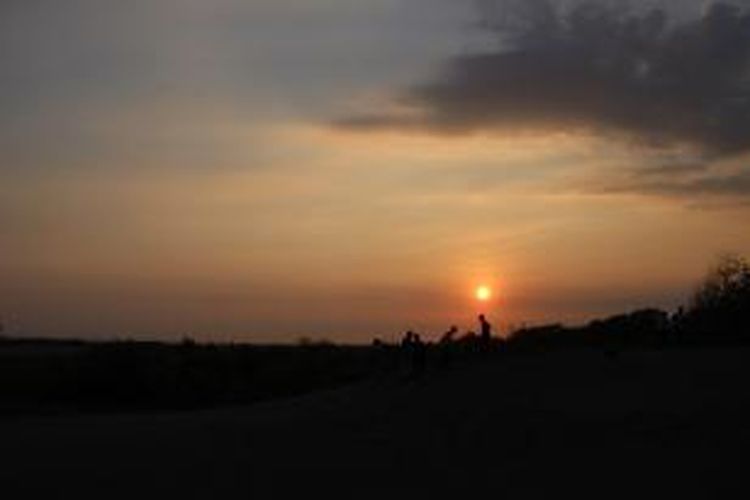 Wisatawan menikmati matahari tenggelam dari Gumuk Pasir Parangkusumo, Bantul, Yogyakarta, Minggu (23/8/2015). Untuk masuk ke area Gumuk Pasir Parangkusumo, wisatawan tidak dikenakan biaya.