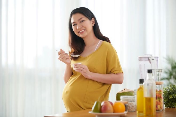 Wanita hamil mengonsumsi makanan bergizi.