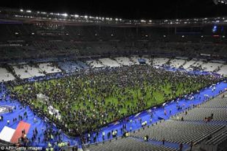 Penonton Pertandingan Prancis vs Jerman mengerumuni lapangan Stadion Stade de France di St-Denis, Paris setelah terdengarnya ledakan bom