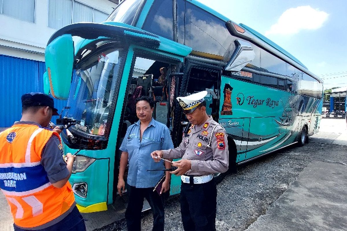 Petugas gabungan melakukan pemeriksaan kelengkapan peralatan keamanan di bus.
