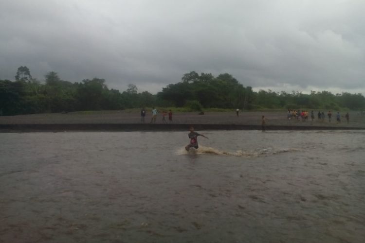 Anak-anak SD dan SMP Satap Nangalanang di Kabupaten Manggarai Timur, Flores, NTT menyeberangi Kali Pinarangkat, Rabu (19/6/2019).