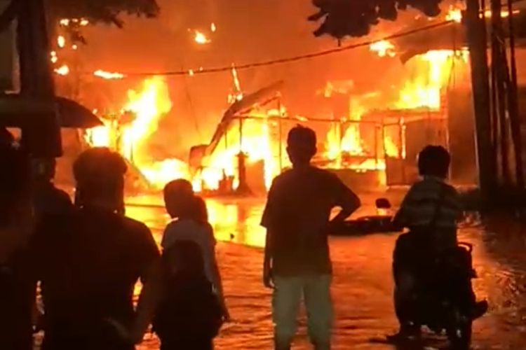 Warga menyaksikan kobaran api saat membakar dua toko di Jalan Cipta Karya, Kelurahan Sialang Munggu, Kecamatan Tuah Madani, Kota Pekanbaru, Riau, Senin (1/4/2024).