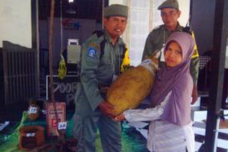 Jumiasih (43) saat menerima hadiah doorprize berupa Nangka berukuran besar usai memberikan hak suaranya di TPS 17 Dusun Balong Kelurahan Donokerto Kecamatan Turi Kabupaten Sleman
