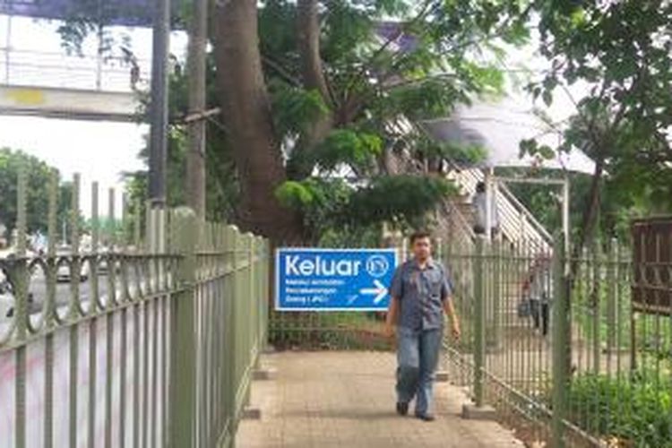 Salah seorang calon penumpang KRL Commuter Line melewati jalan akses keluar masuk Stasiun Tanjung Barat, Jumat (26/12/2014). Kini, keluar masuk Stasiun Tanjung Barat harus melalui jembatan penyeberangan karena pintu utama stasiun yang menghadap jalan raya telah ditutup