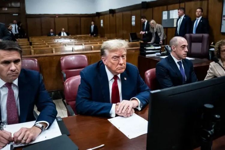 Donald Trump duduk di meja terdakwa dengan tim hukumnya dalam persidangan.