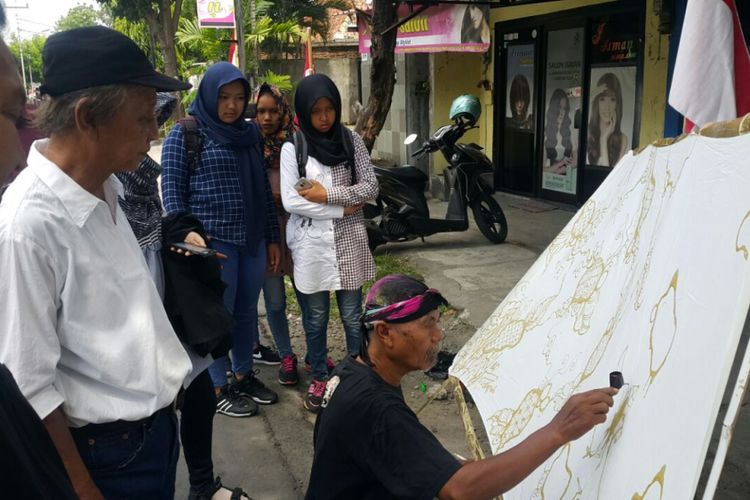 TONTON-Warga setempat menonton peserta yang membatik di kain putih di acara mBatik bareng pada Napak Budaya Samanhoedi di Jalan KH Samanhoedi, Sondakan, Kecamatan Laweyan, Kota Solo, Kamis ( 2/11/2017) siang.