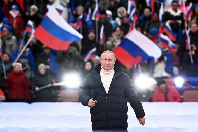 Presiden Rusia Vladimir Putin menghadiri konser yang menandai ulang tahun kedelapan pencaplokan Krimea oleh Rusia di stadion Luzhniki di Moskow pada Jumat (18/3/2022).