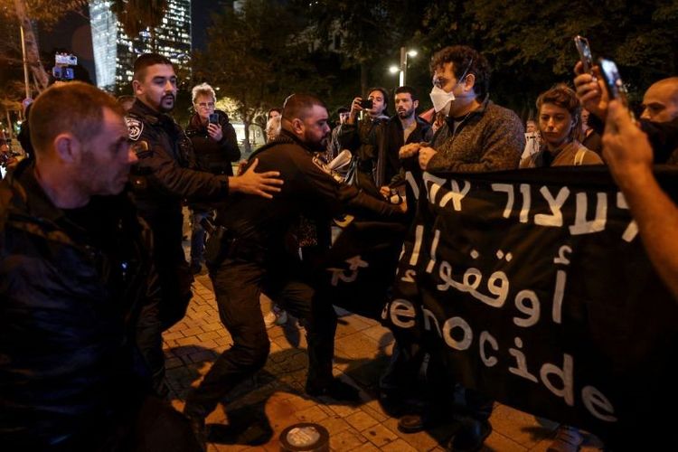 Polisi Israel mengambil spanduk saat demonstrasi anti-perang di Tel Aviv pada Selasa (16/1/2024) malam.