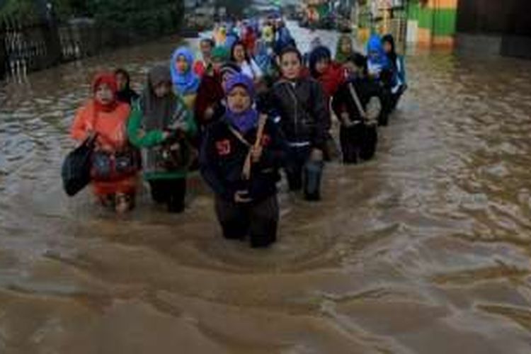 Sejumlah buruh melintasi Jalan Raya Banjaran, Kecamatan Baleendah, Kabupaten Bandung, yang terendam banjir luapan Sungai CItarum, Rabu (8/6/2016).