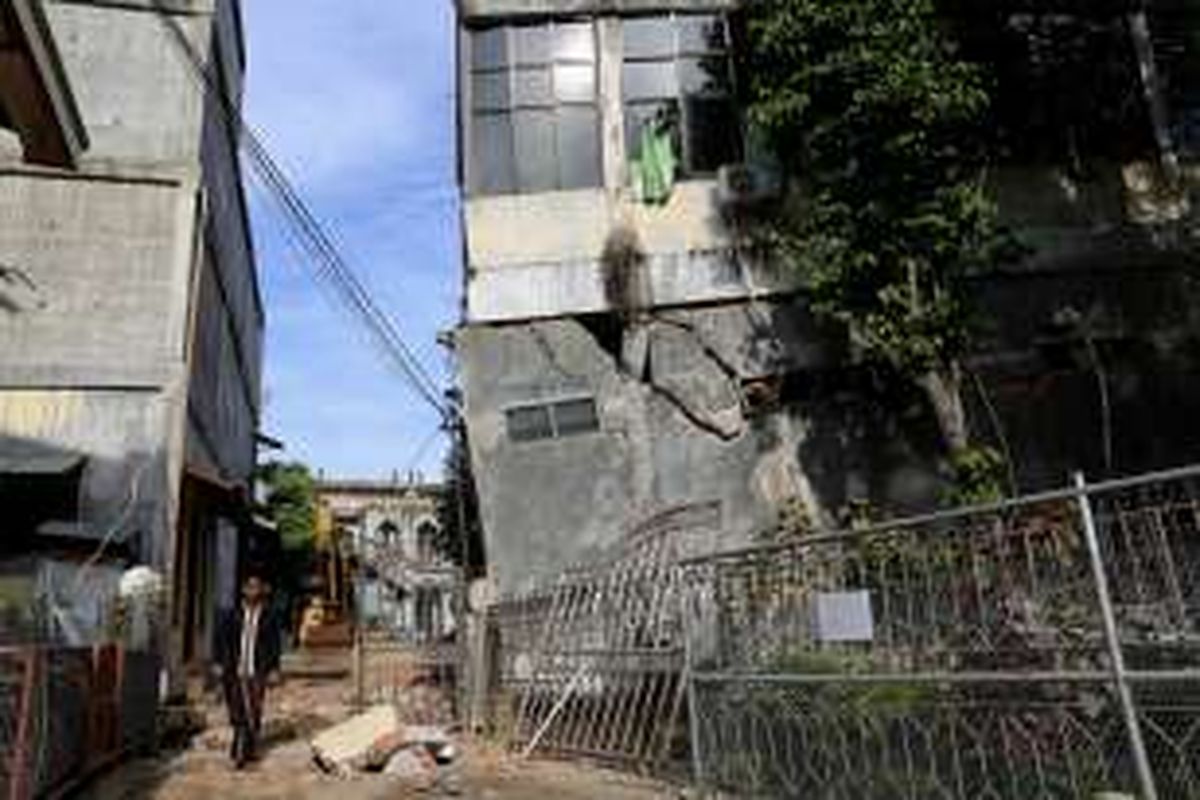 Warga melintas di samping bangunan pondok pesantren di bawah Lembaga Pendidikan Islam Ma'hadal Ulum Diniyah Islamiyah roboh akibat gempa di Samalanga, Kabupaten Bireun, Aceh, Sabtu (10/12/2016). Presiden joko Widodo berjanji untuk secepatnya dilakukan pembangunan kembali dan  akan ditangani oleh Kementerian Pekerjaan Umum dan Perumahan Rakyat.