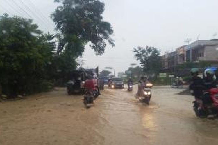Pengendara melintas di lokasi banjir lintas Medan-Banda Aceh, Desa Alue Awee, Kota Lhokseumawe