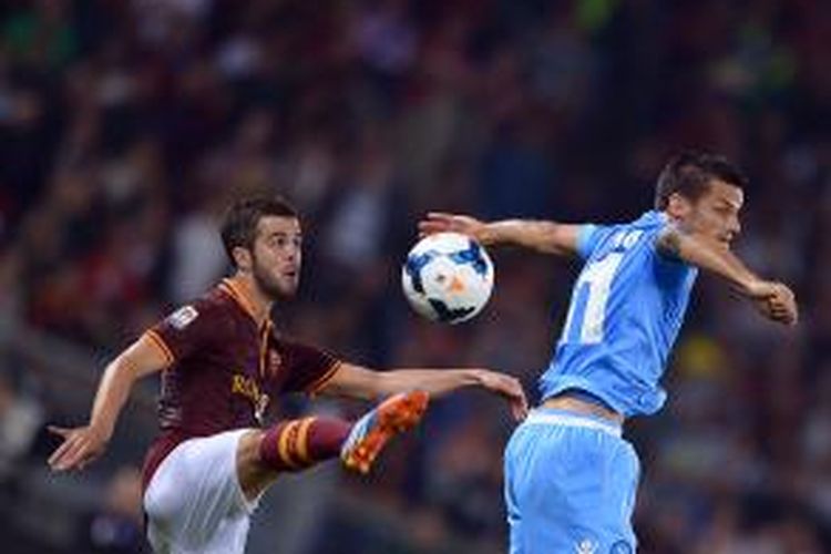 Gelandang AS Roma asal Bosnia, Miralem Pjanic (kiri), berduel dengan gelandang Napoli Christian Maggio dalam laga Serie-A di Olimpico, Jumat (18/10/2013).