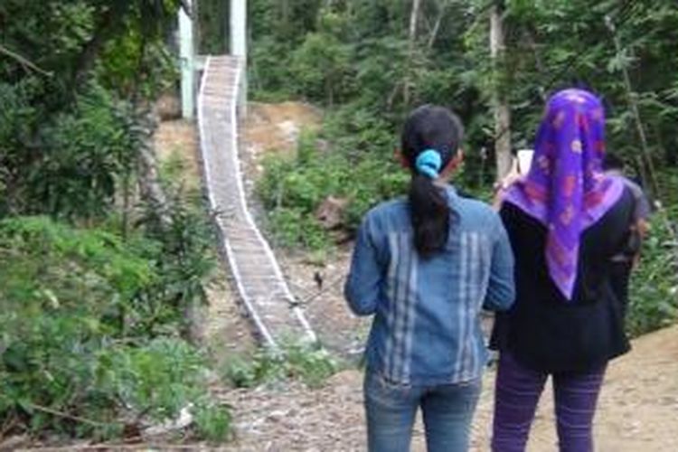 Dua gadis di Kabupaten Bone, Sulawesi Selatan tengah mengabadikan jembatan yang ambruk saat tengah diresmikan dengan ritual ada dan melukai 7 warga. Jumat, (20/02/2015).